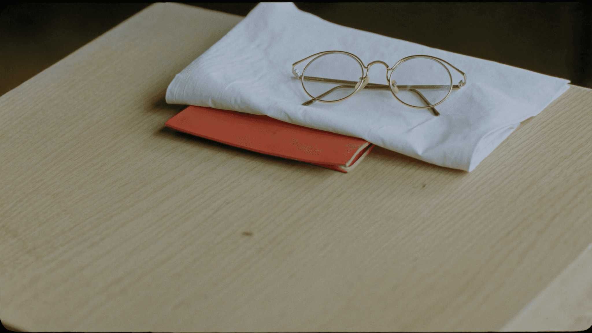 Laptop on a desk playing pastel isometric medical animation, papers and mug beside
