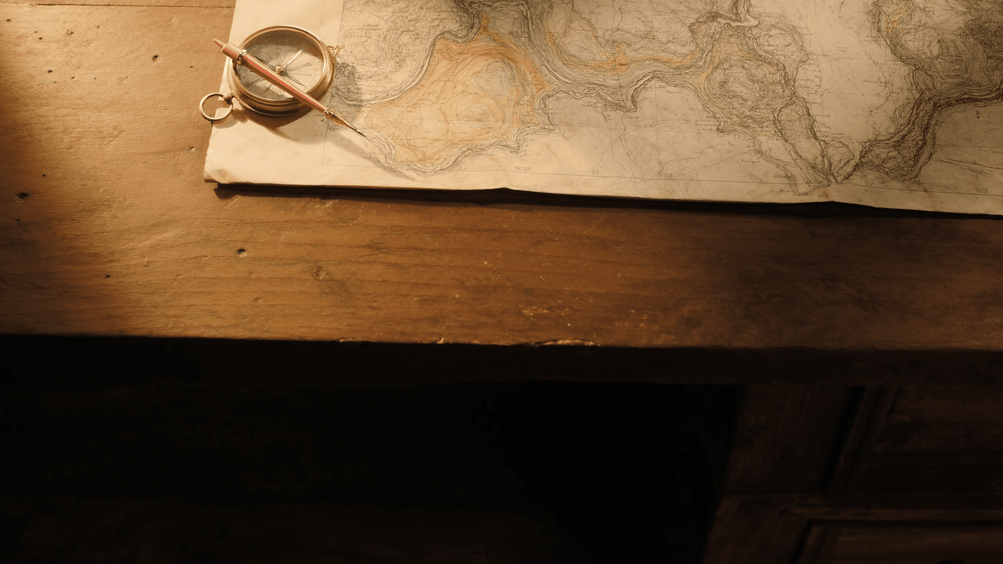 Editorial still: a brass compass and pencil resting on a topographic map