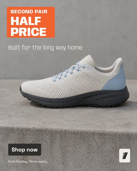 Example ad, the running-shoe client’s feed ad: one off-white shoe on a concrete step, an orange offer block top left, a thin pale headline, a charcoal button, small print and a small mark bottom right.