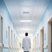 Example frame: a doctor walking down a bright corridor